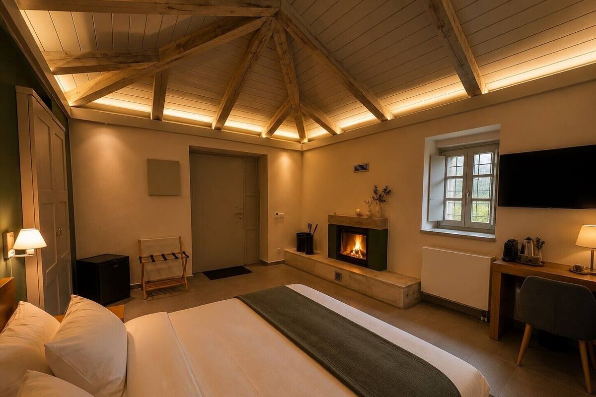 Un dormitorio con cama, chimenea, escritorio, televisor y ventana.