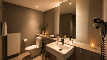 A modern bathroom with a toilet, sink, and mirror.