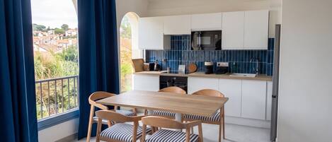 A modern kitchen with white cabinets, a microwave, and a sink.