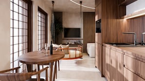 A modern kitchen with wooden cabinets, a round dining table, and a built-in TV.
