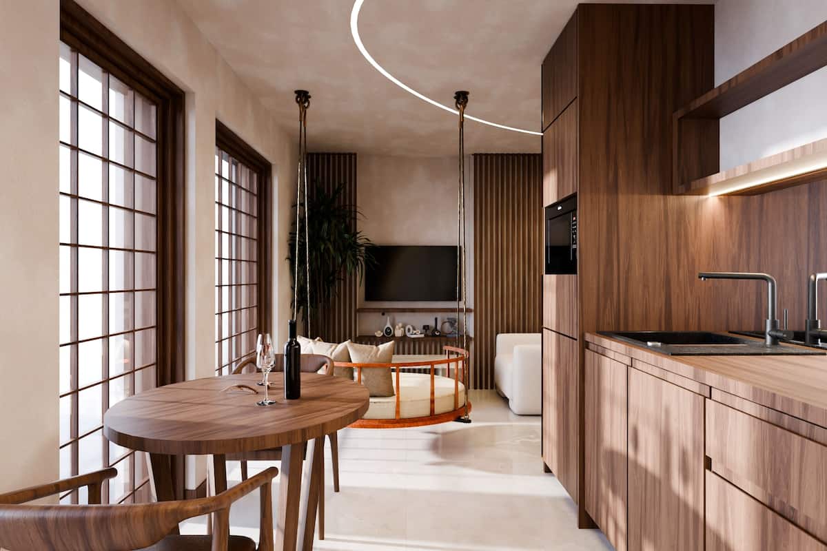 A modern kitchen with wooden cabinets, a round dining table, and a built-in TV.