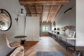Eine moderne Küche mit Holzbalken, einem Essbereich mit Tisch und Stühlen sowie Blick ins Freie.