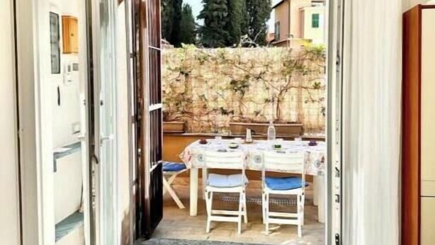 Una habitación con puerta corrediza de vidrio que da a un espacio exterior con mesa y sillas.