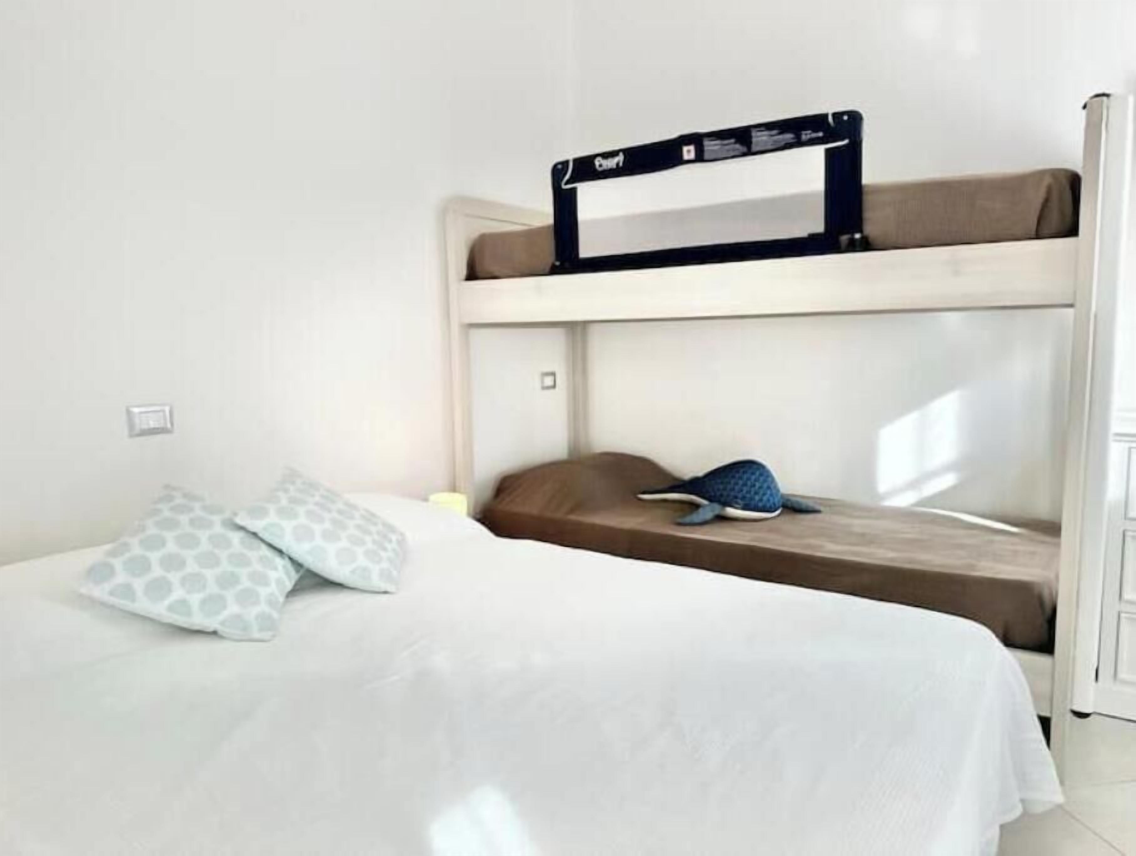 A bunk bed room with a desk, a pillow, and a blanket.