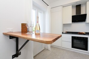 Eine Küche mit einer Holzausziehtheke, einer Champagnerflasche und zwei Gläsern.