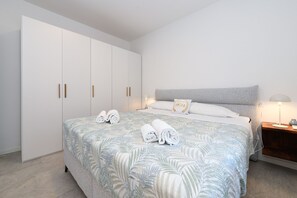 Ein Schlafzimmer mit einem Bett, einem Kleiderschrank und einem Nachttisch mit einer Lampe.