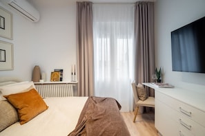Ein modernes Schlafzimmer mit Bett, Nachttisch und Schreibtisch mit Stuhl.