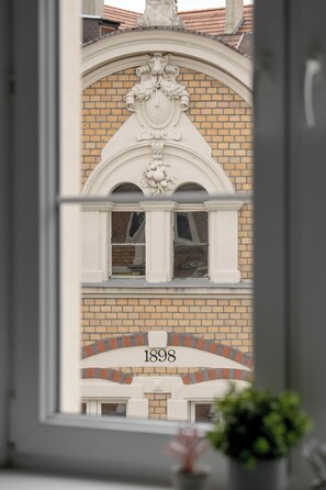 Eine Gebäudefassade mit Backsteinmuster und einem dekorativen Bogen, das Jahr '1898' ist angegeben.