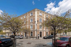 Ein mehrstöckiges Gebäude mit Ziegelverkleidung, großen Fenstern und einem zentralen Eingang.
