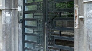 A large, ornate metal gate with a glass panel above it, set within a stone structure. - Luxury l Apartment | Radisson | Calea Victoriei (Bucharest)