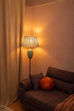 A room with a sofa, a lamp, and a curtain. - Luxury l Apartment | Radisson | Calea Victoriei (Bucharest)