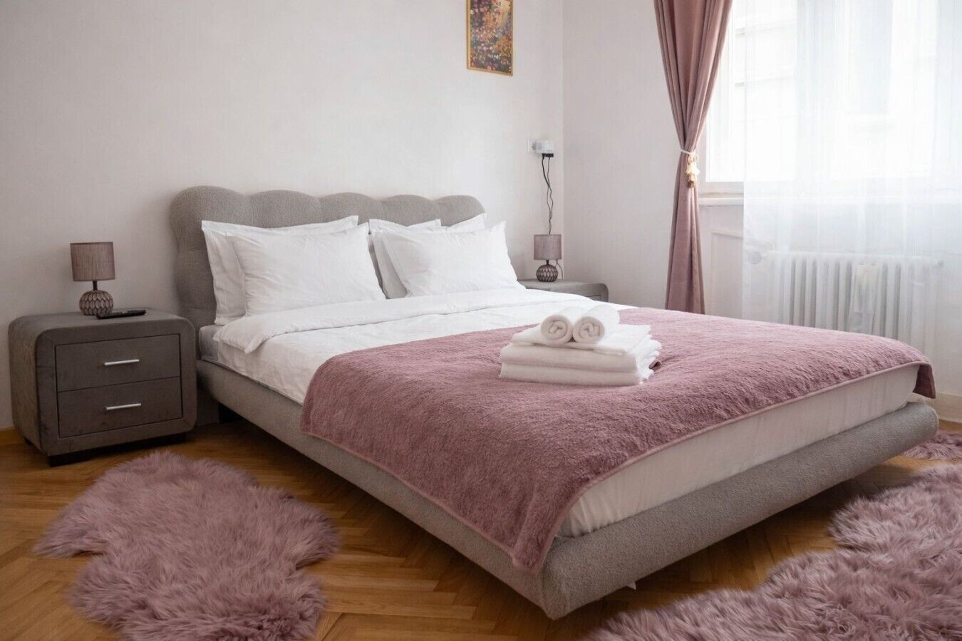 Une chambre à coucher avec un lit, une table de chevet, une lampe et une fenêtre avec des rideaux.
