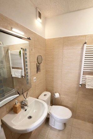 Ein modernes Badezimmer mit Waschbecken, Toilette und Spiegel.