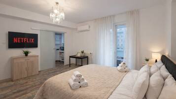 Une chambre d’hôtel équipée d’un lit, d’une télévision, d’un bureau, d’une chaise, d’une fenêtre et d’une porte.