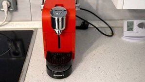 A red coffee machine on a kitchen counter with a white wall and cabinets in the background. - Modern Studio Apartment | Comfortable & Center (Bucharest)