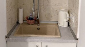 Eine Küche mit Spüle, Wasserhahn, Kaffeemaschine und Küchenpapier.