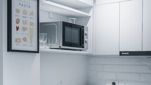 A modern kitchen with a microwave, sink, and coffee maker. - Downtown Loft with Panoramic View (Bucharest)