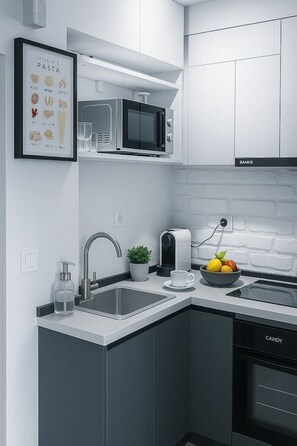 Eine moderne Küche mit Mikrowelle, Spüle und Kaffeemaschine.