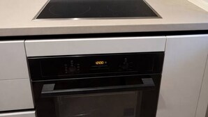 Eine Küche mit eingebautem Kochfeld, Backofen und Geschirrspüler.