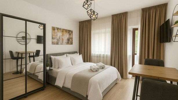 Een moderne hotelkamer met een bed, een bureau, een stoel, een televisie en een grote spiegel.