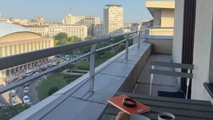 Ein Balkon mit Tisch, einer Platte mit einem Hund und einer Tasse.