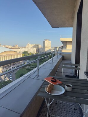 Ein Balkon mit Tisch, einer Platte mit einem Hund und einer Tasse.