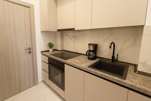 A kitchen with a built-in dishwasher, a coffee maker, and a sink. - Stylish & Comfortable Studio Retreat (Bucharest)