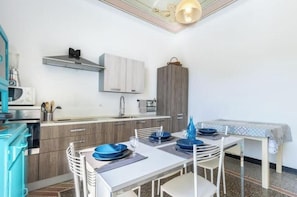 A compact kitchen with a dining area, a microwave, a sink, and cabinets.