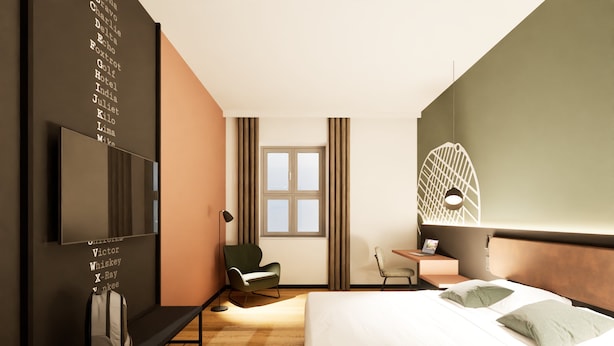 Quarto de hotel moderno com cama, escrivaninha, cadeira, televisão e parede com texto.