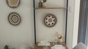 A dining area with a wooden table, two grey chairs, and a black metal frame.