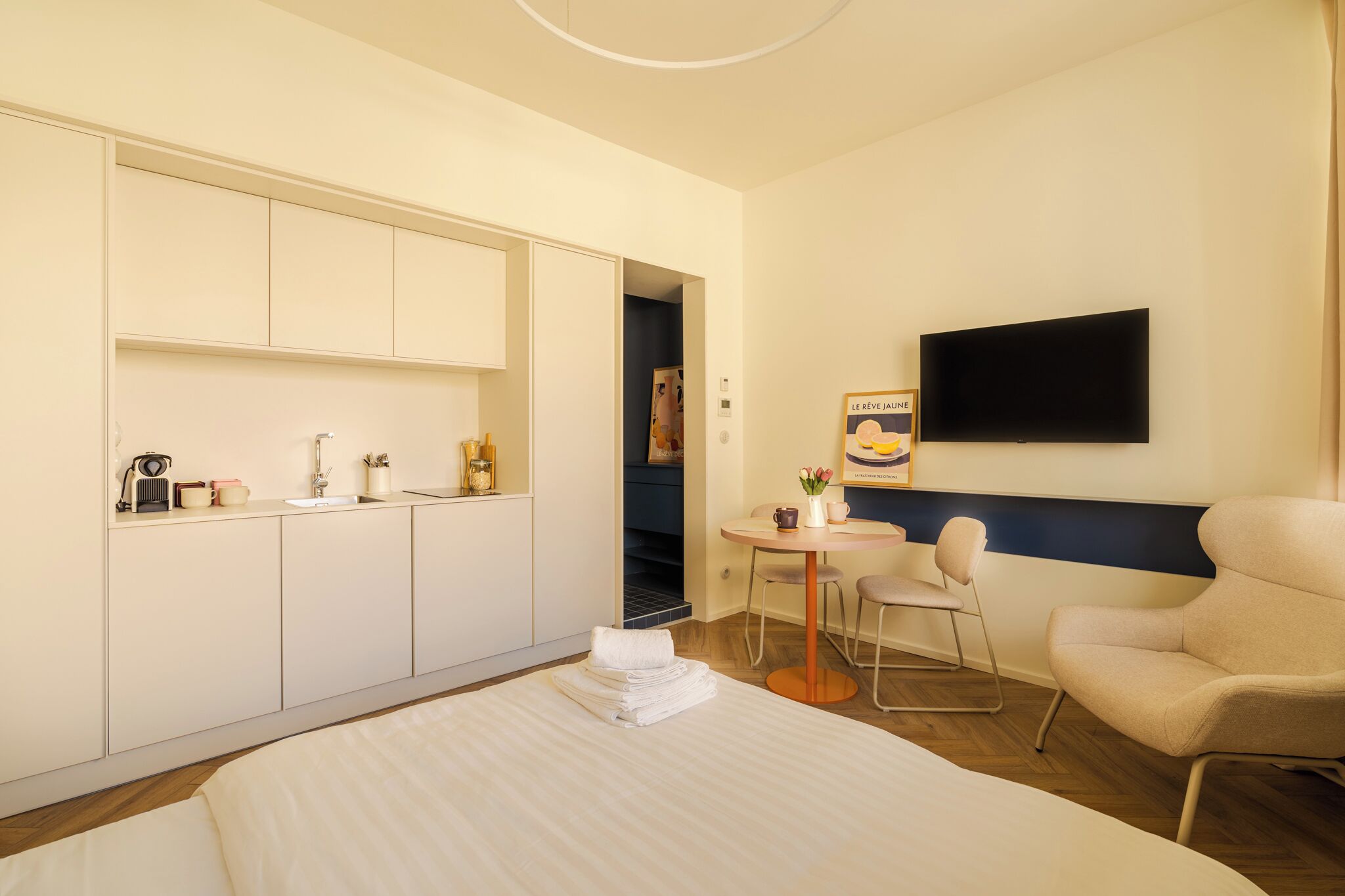 Una camera d'albergo con un letto, una scrivania con sedia, una televisione e un armadio.