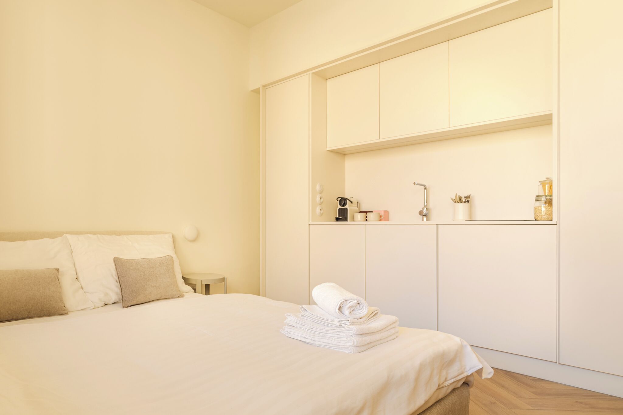 Une chambre d’hôtel avec un lit, une armoire et une petite table avec des articles de toilette.