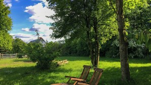 A wooden bench in a grassy field with trees and a fence in the background. - Artist apartment at Aukrug nature park (Meezen)