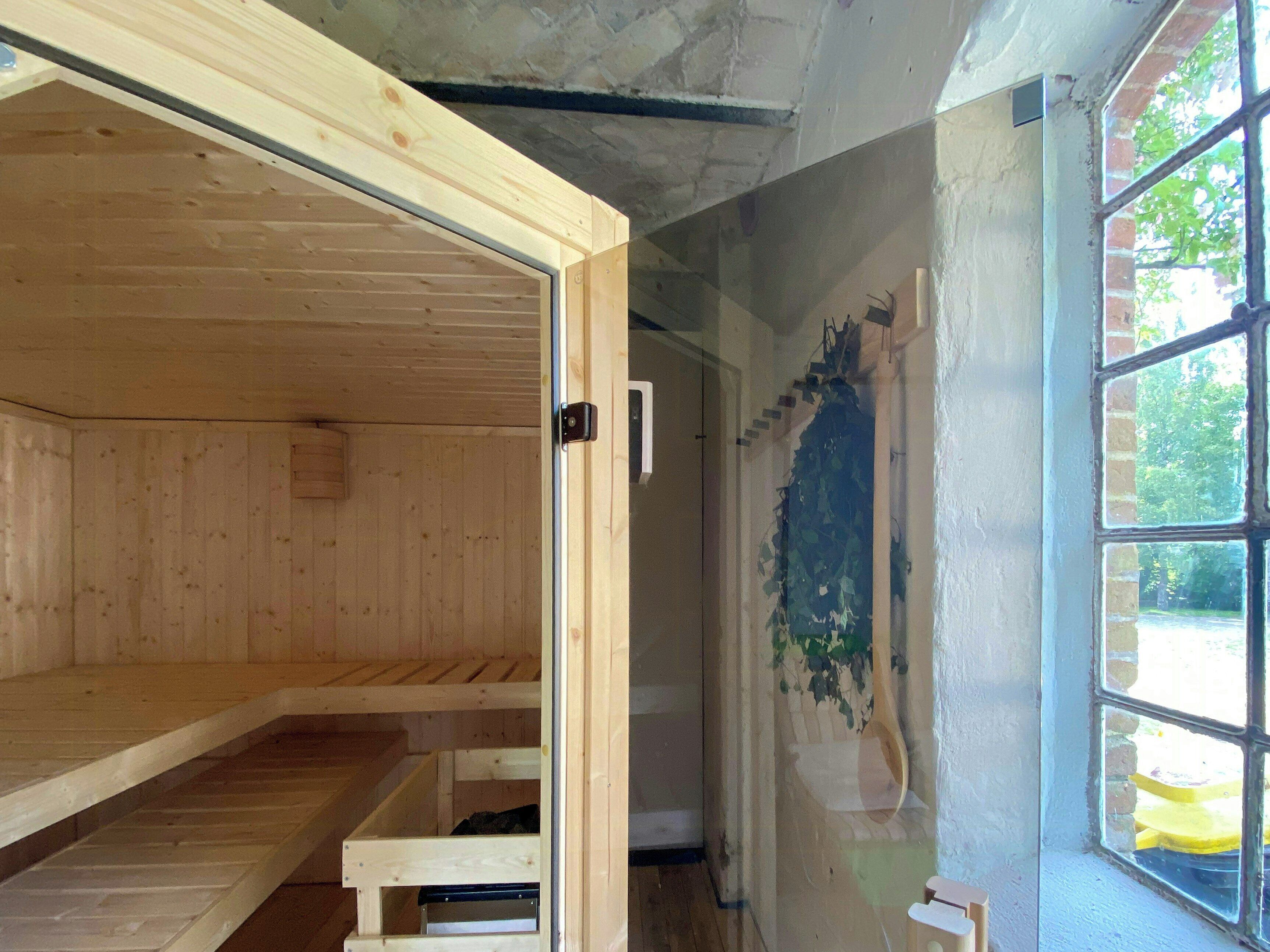 Ein Zimmer mit Holzwänden, einem Fenster und einer Tür.