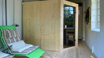 A room with a wooden door, a green chair, and a small table.