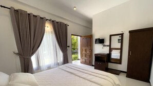 A bedroom with a large bed, curtains, a television, a wardrobe, and a door leading to a balcony. - The Reef Resort Nilaveli - Trincomalee (Nilaveli)