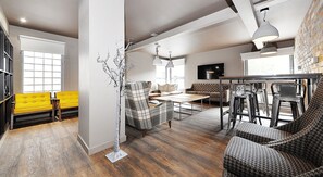 A modern living room with a sofa, chairs, a coffee table, and a TV. - Student Only Marketgait (Dundee)