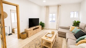 Ein Wohnzimmer mit Fernseher, Sofa und Couchtisch.