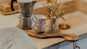 A kitchen counter with a coffee maker, a cup, and a vase with dried plants. - 16th century farmhouse between the Tuscan hills (Monteverdi Marittimo)
