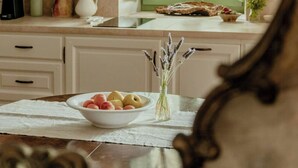A kitchen with a green window, white cabinets, and a bowl of fruit on the table. - 16th century farmhouse between the Tuscan hills (Monteverdi Marittimo)