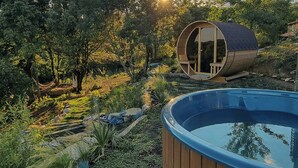 A cylindrical wooden structure with a glass door, a wooden deck, and a swimming pool. - 16th century farmhouse between the Tuscan hills (Monteverdi Marittimo)