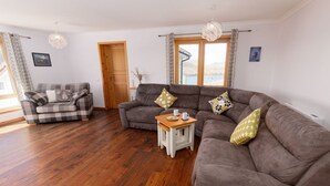A living room with a checkered sofa, a brown sofa, and a wooden coffee table. - NEW to VRBO: Spacious House w/ Coastal Views & Private Garden (Whiteness)