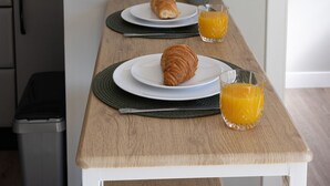 Ein Frühstückstisch mit einem Croissant, Orangensaft und einem gerahmten Bild.
