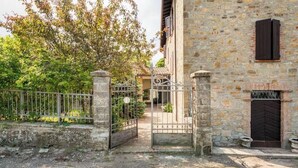 Un edificio de piedra con una entrada porticada, una puerta y una ventana.