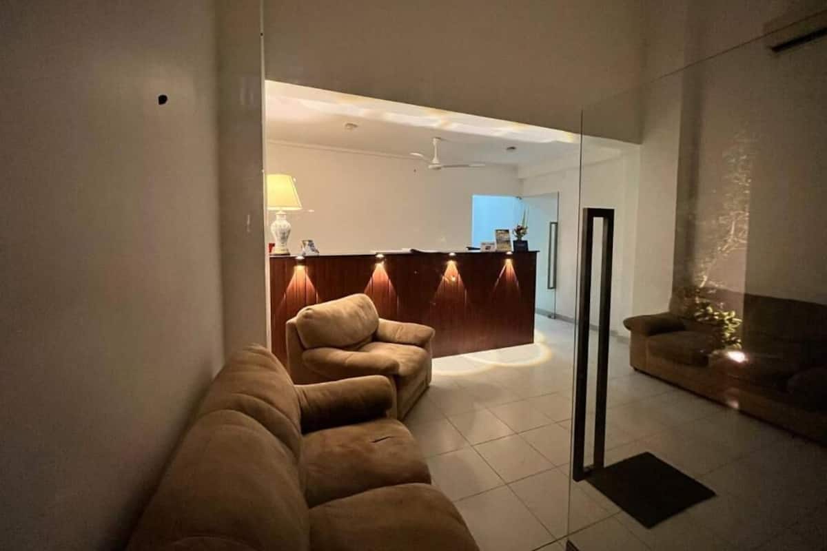 Ein modernes Wohnzimmer mit einer Couch, einem Empfangstresen und einer Glastrennwand.