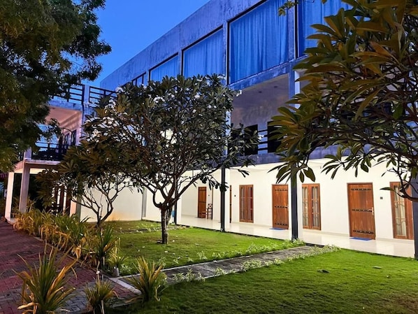 A building with a modern architectural style, featuring a covered walkway and a well-maintained lawn.