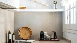 Uma cozinha compacta com design moderno, equipada com forno embutido, espaço para café e pequena área de armazenamento.