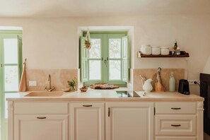 A kitchen with a window, a sink, cabinets, and a shelf with jars and a kettle. - Apartment in a 16th century farmhouse (Monteverdi Marittimo)