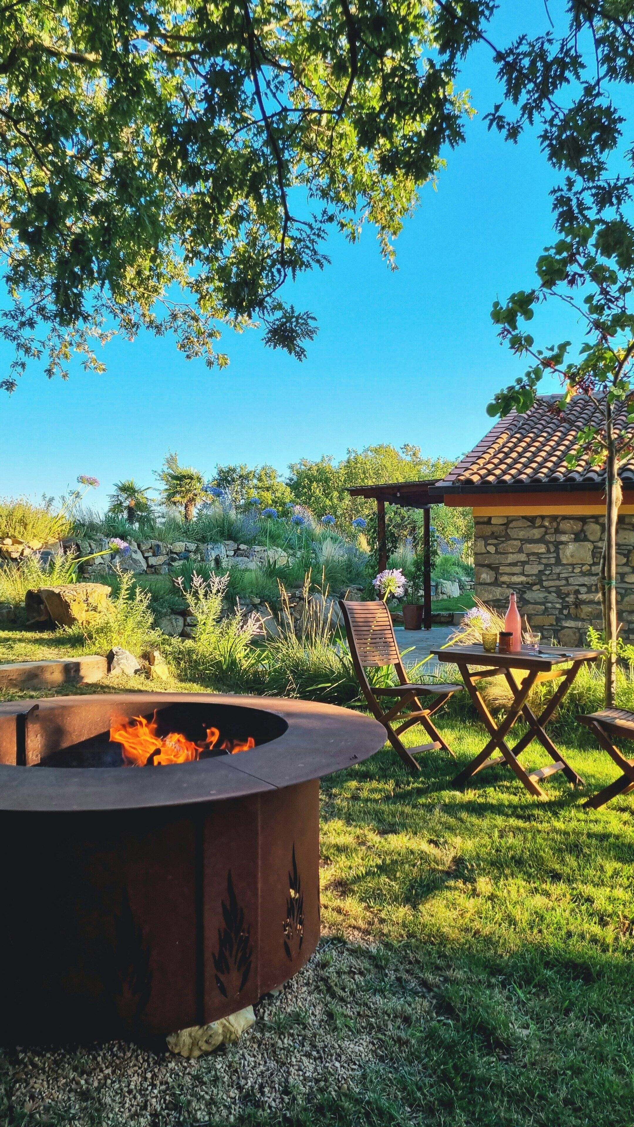 Una chimenea, asientos exteriores y un edificio de piedra.