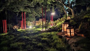 A garden with red poles, a lantern, and trees. - Apartment in a 16th century farmhouse (Monteverdi Marittimo)